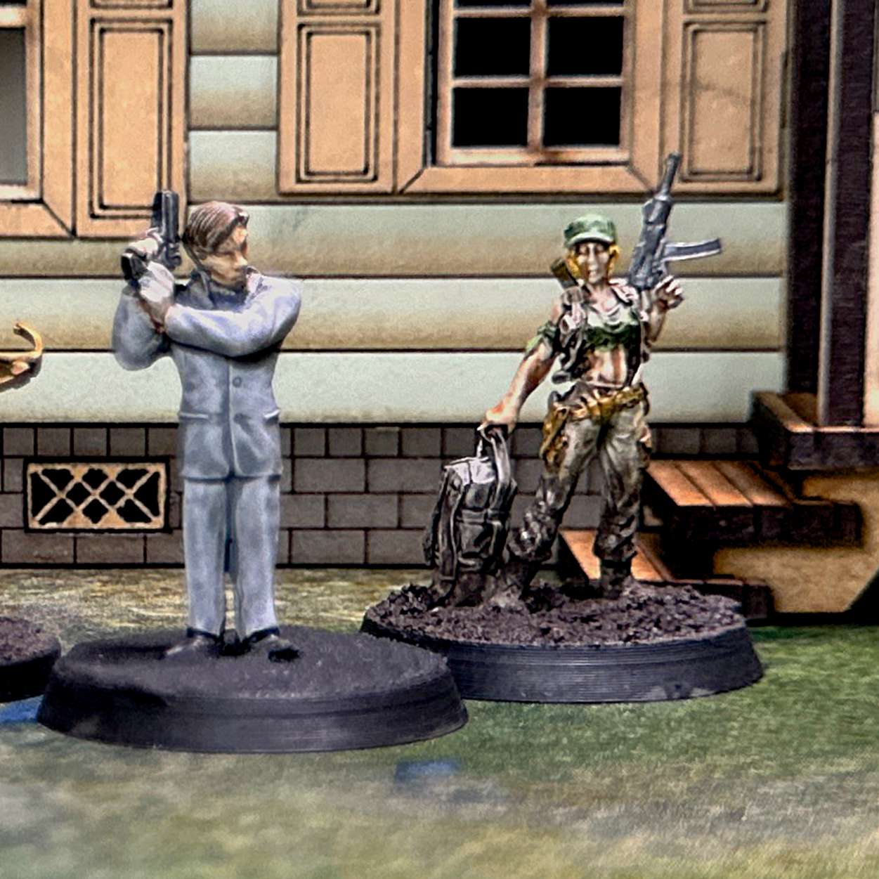 a photo of the miniatures used for the community in the first mission: in the center is a man in a grey business suit carrying a pistol, on the left is a man in a green t-short and blue jeans carrying a crossbow, on the right is a woman wearing military fatigues and carrying a pistol