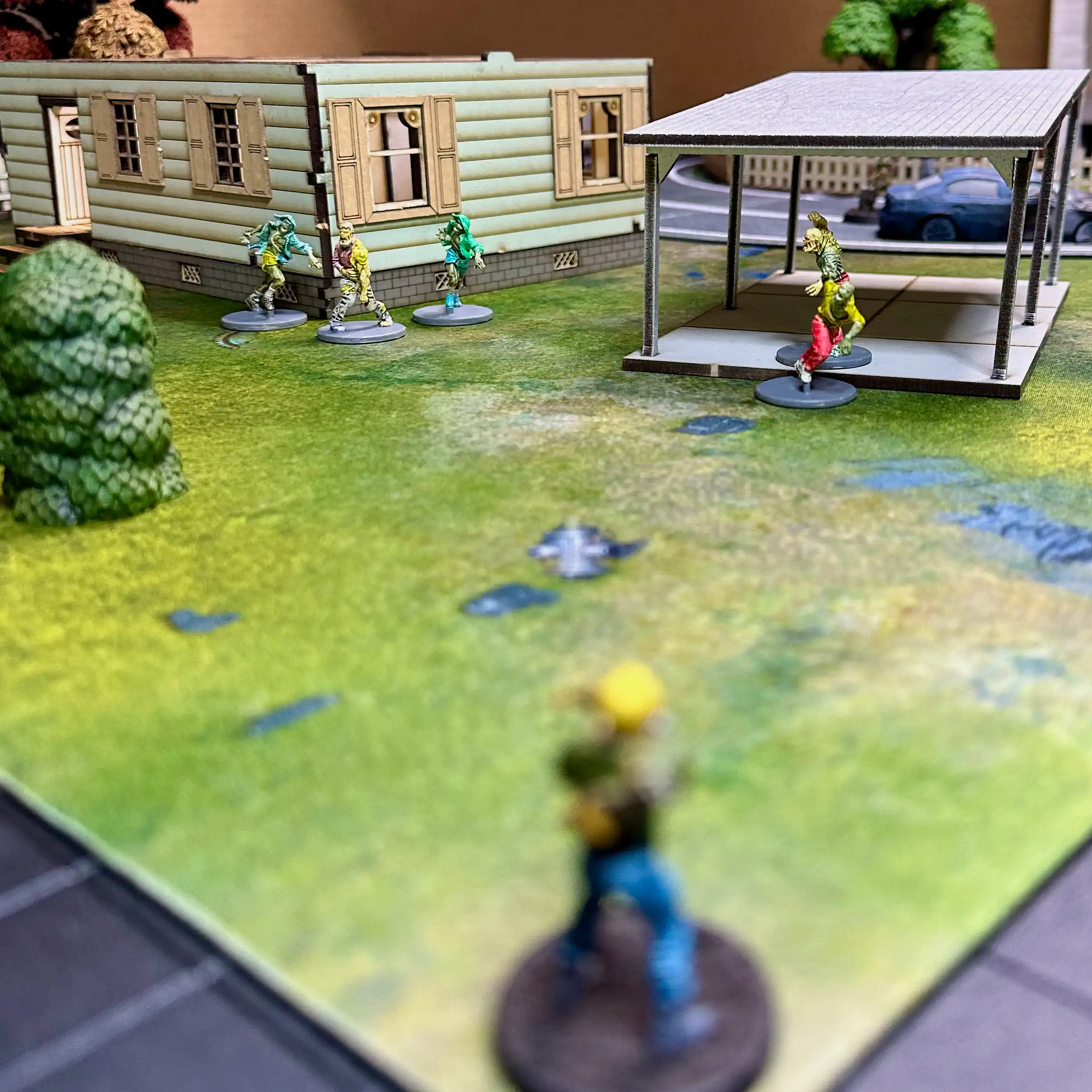 photo taken from above the head of the narrator's miniature standing in the corner of the board with the zombie horde approaching
