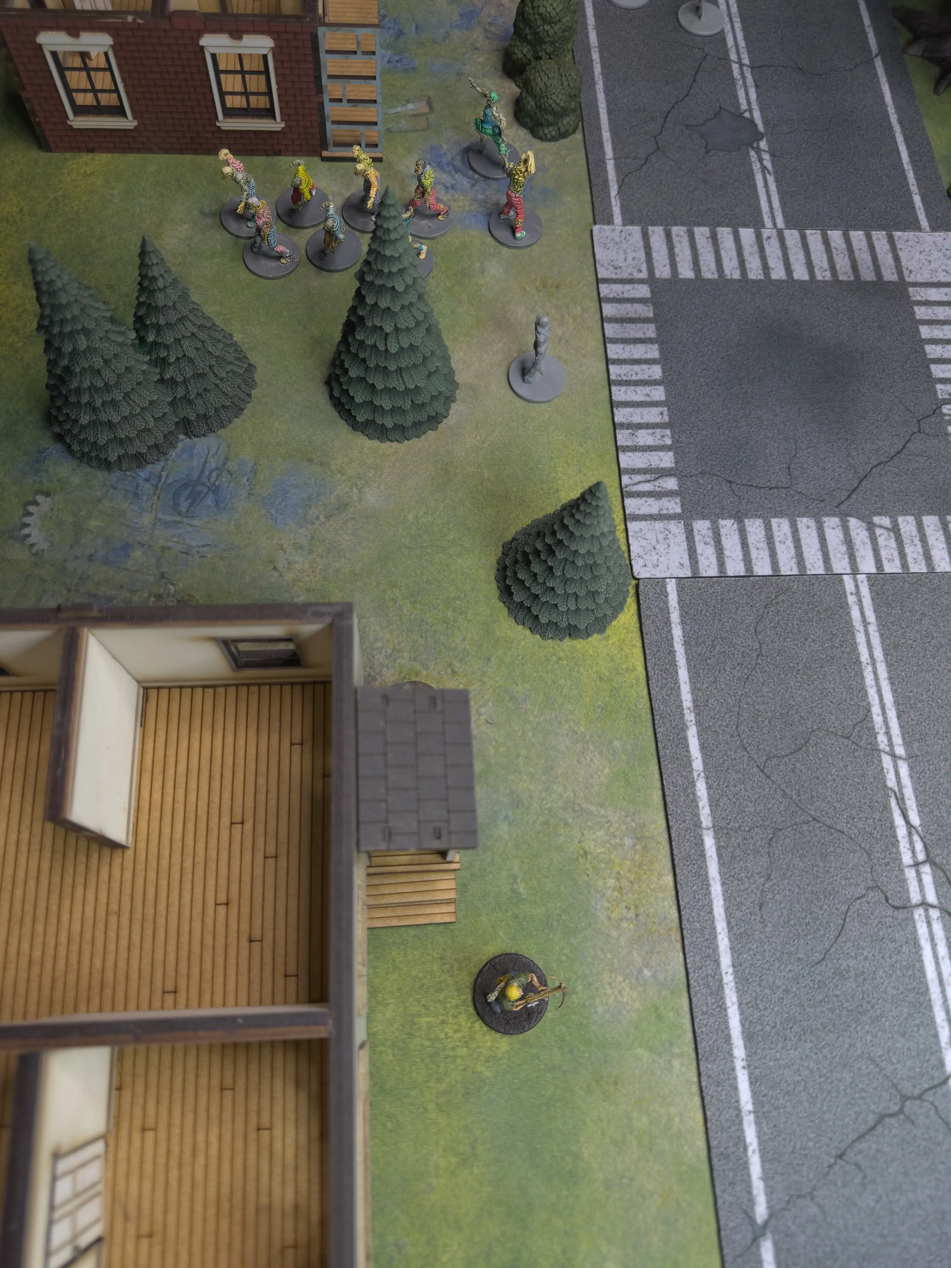 the narrator's miniature is in the foreground and in the background are nine zombies outside the other house