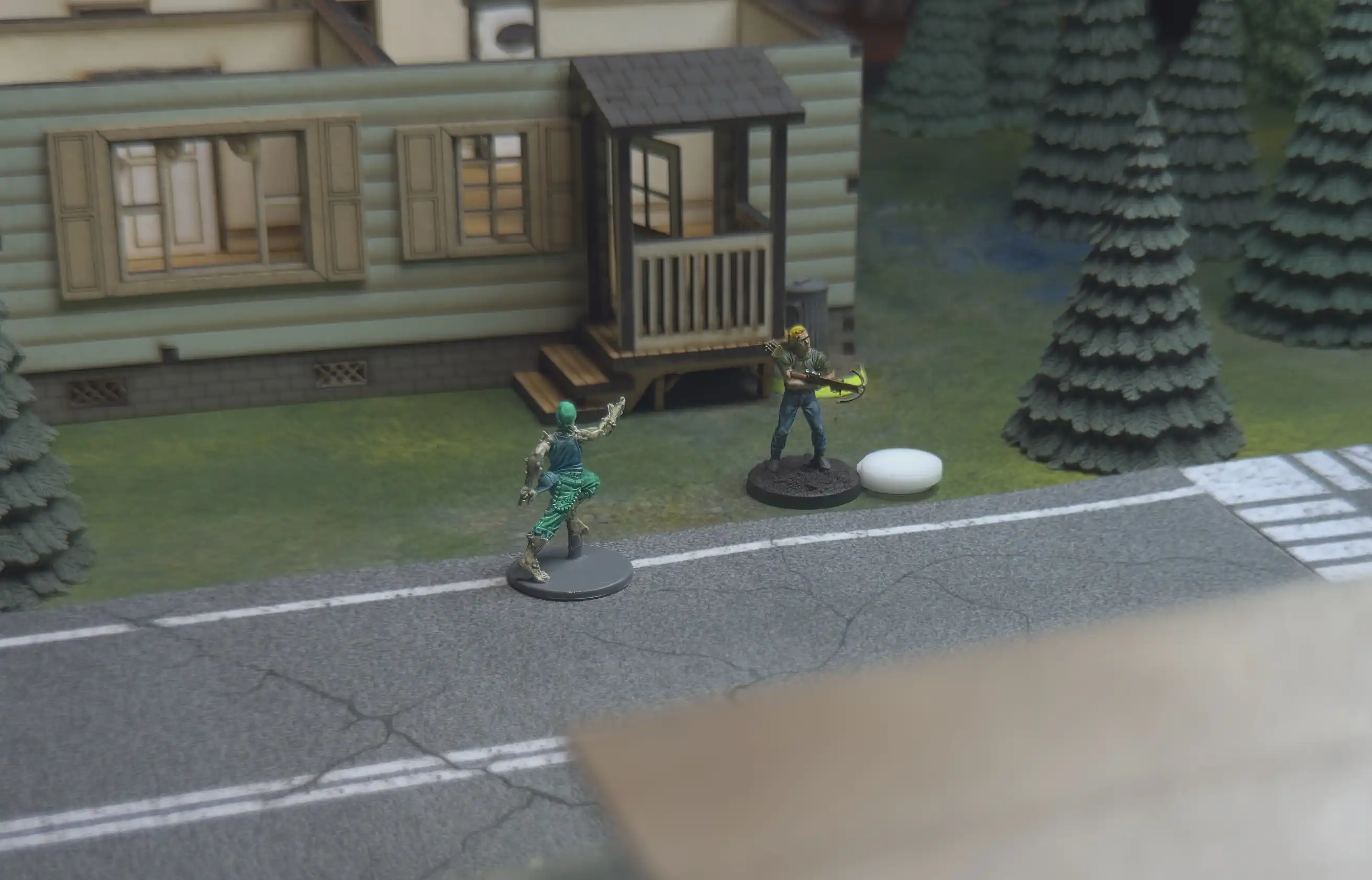 photo taken over-the-shoulder of the narrator's miniature looking toward a horde of zombies half-way across the table
